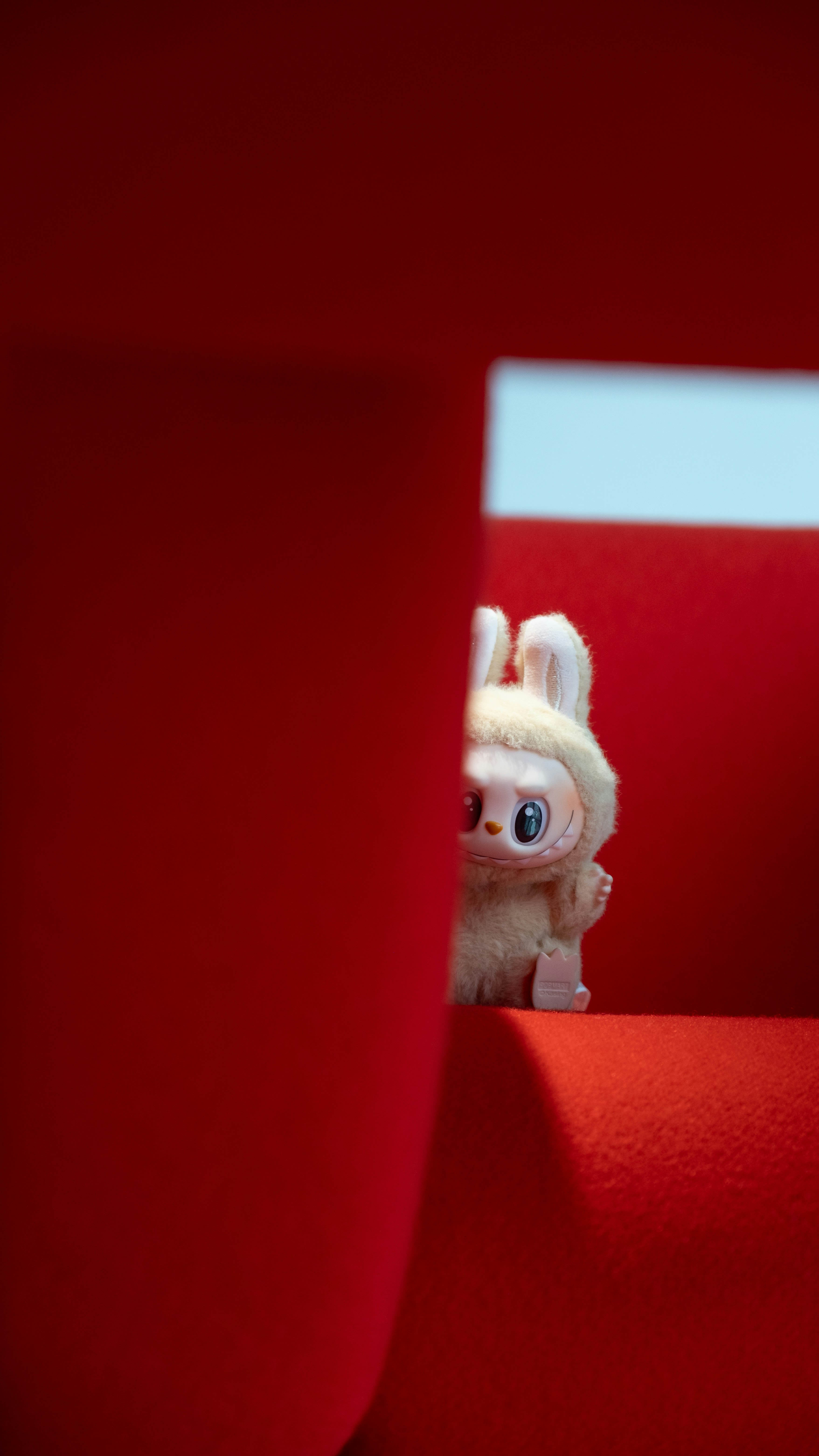 A curious toy peeks out from behind red.