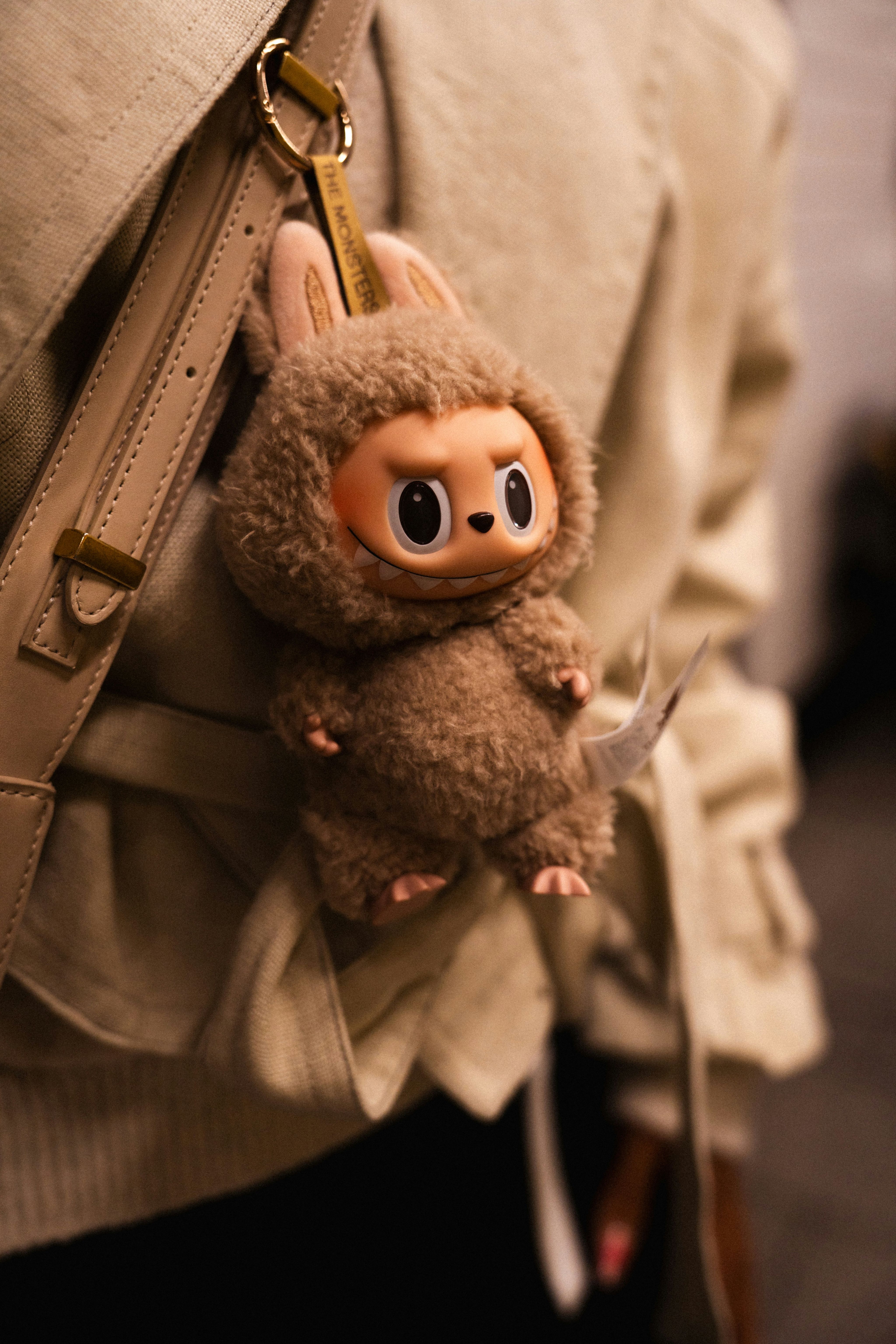 A plush toy keychain hangs from a purse.